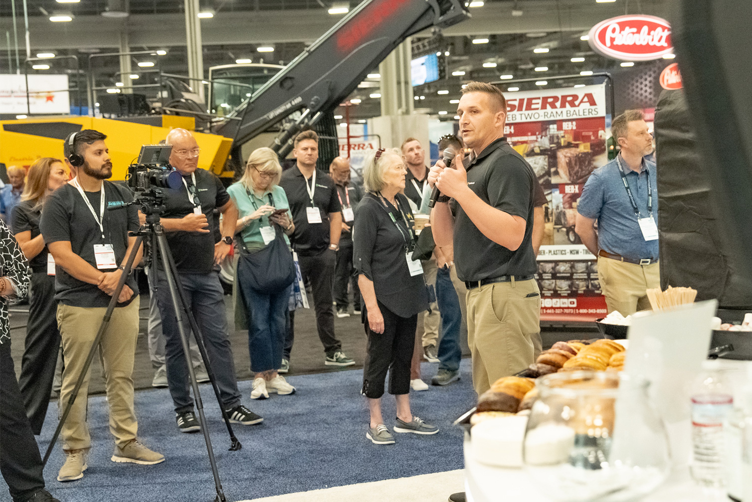 A man speaking into a microphone in front of a group of people