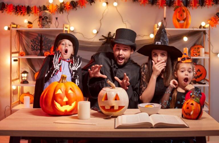 A family trying to look scary on halloween while surrounded by pumpkins, candy, and decorations