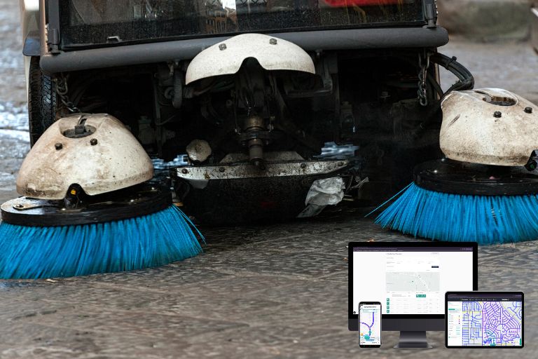 Street sweeper vehicle cleaning a city roadway with digital route tracking and performance analytics overlay.